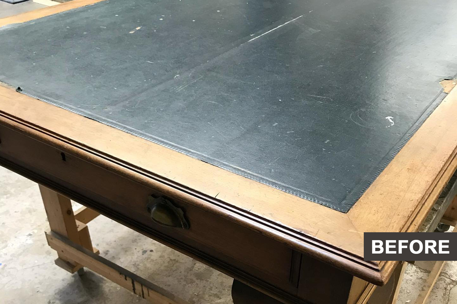 A desk with a black top before restoration