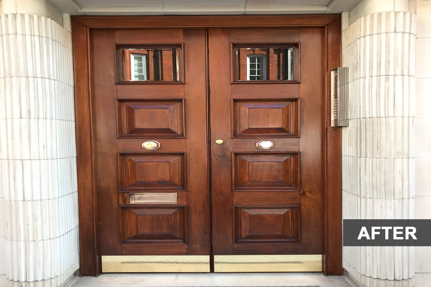 Wooden door with brass handles after restoration.